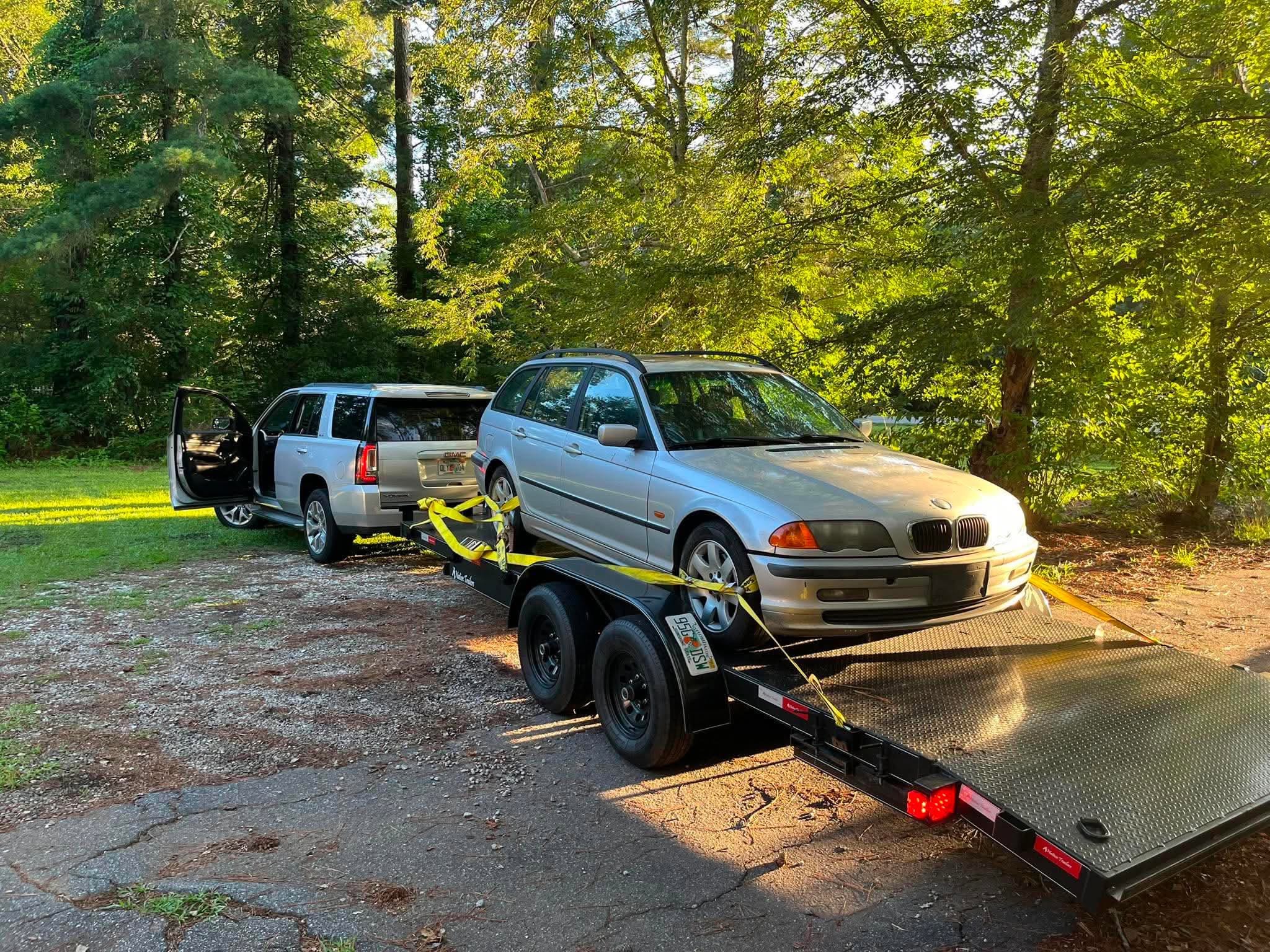 Station wagon tied down on the steel deck trailer