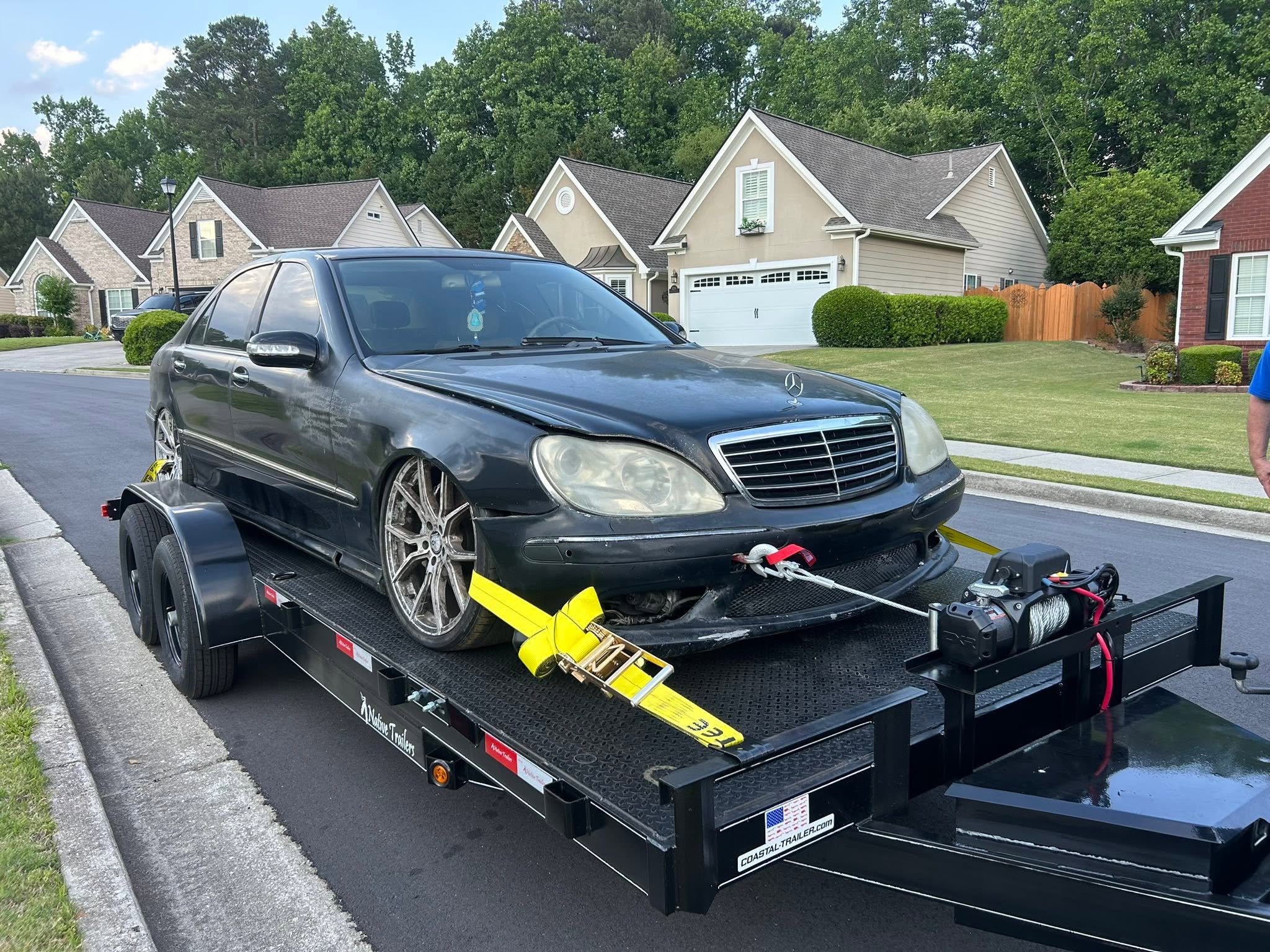 Low sedan winched onto the steel deck trailer with D-ring tie-downs
